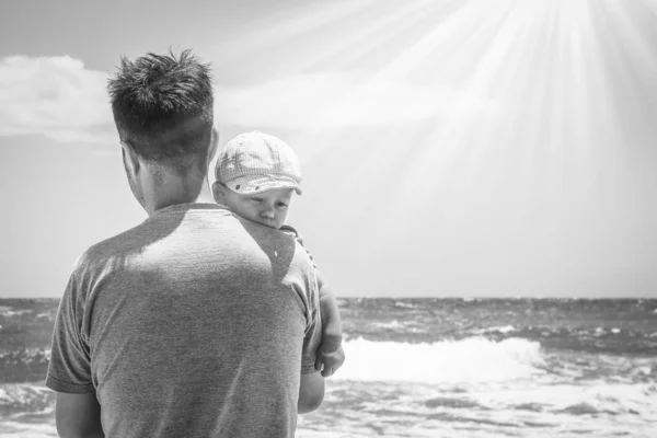 Padre feliz con un niño junto al mar al aire libre — Foto de Stock