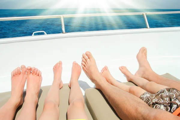 Elegantes piernas hermosas en un yate de barco en el fondo del mar —  Fotos de Stock