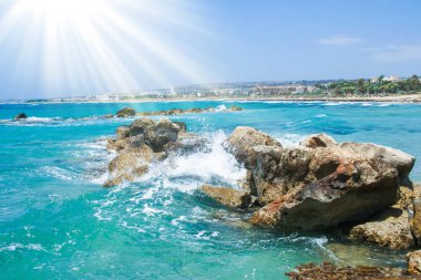 Arka planda dalgalar olan güzel bir sahil.