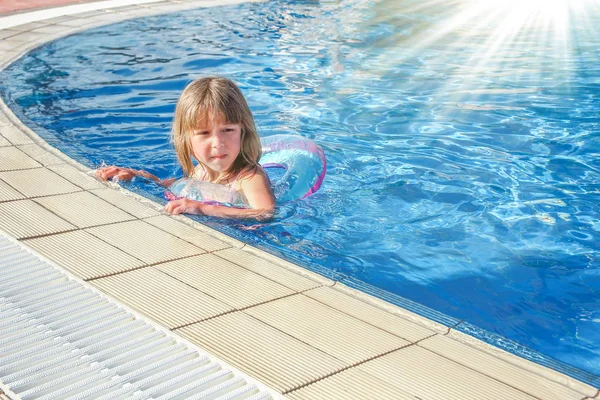 Un niño feliz juega junto a la piscina junto al mar — Foto de Stock