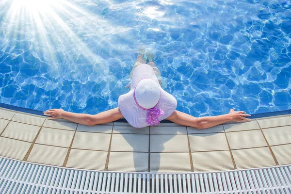 Szczęśliwa dziewczyna w kapeluszu przy basenie na morzu — Zdjęcie stockowe