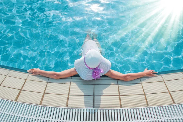Heureuse fille dans un chapeau près de la piscine à la mer — Photo
