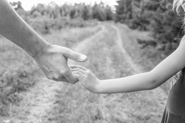 Stilvolle Hände eines Elternteils und eines Kindes in der Natur im Park — Stockfoto