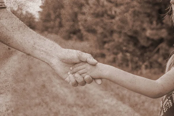 Vieille photo d'une main élégante d'un parent et d'un enfant dans la nature sur un — Photo