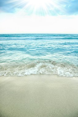 Arka planda dalgalar olan güzel bir sahil.