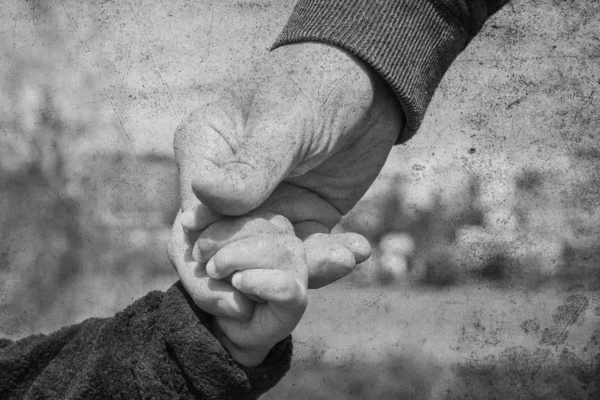 Vieja foto de la mano de un padre y un niño en la naturaleza en una p —  Fotos de Stock