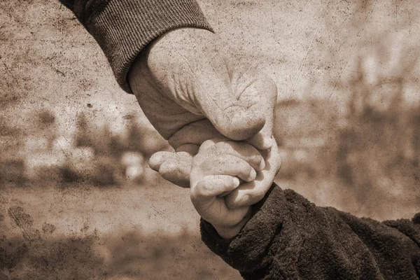 Old photo of the hand of a parent and child in the nature on a p — Stock Photo, Image