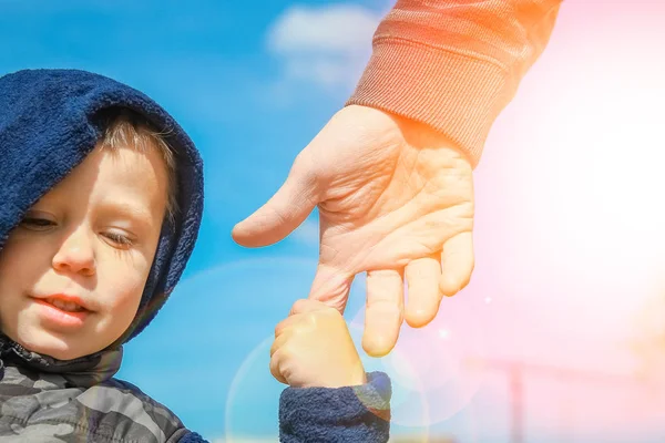 Les mains élégantes d'un parent et d'un enfant dans la nature dans un parc retour — Photo