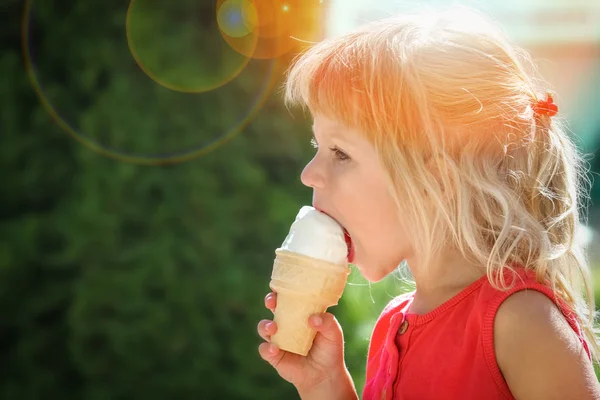 Boldog gyermek eszik fagylaltot a természet a park — Stock Fotó