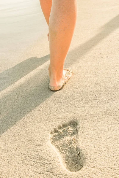 beautiful traces with feet near the sea on nature background