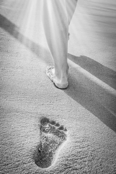 Krásné stopy s nohama v blízkosti moře na přírodním pozadí — Stock fotografie