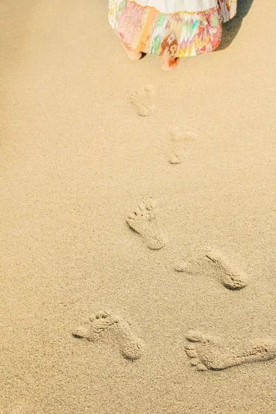 Schöne Fußabdrücke mit Füßen auf dem Sandhintergrund — Stockfoto