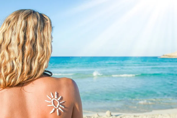 Gelukkig meisje met de zon op haar rug door de zee in de natuur — Stockfoto