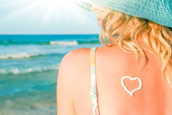 Chica feliz con un corazón en la espalda junto al mar al aire libre —  Fotos de Stock