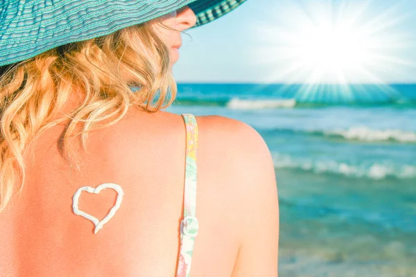 Boldog lány szívvel a hátán a tenger mellett a szabadban — Stock Fotó