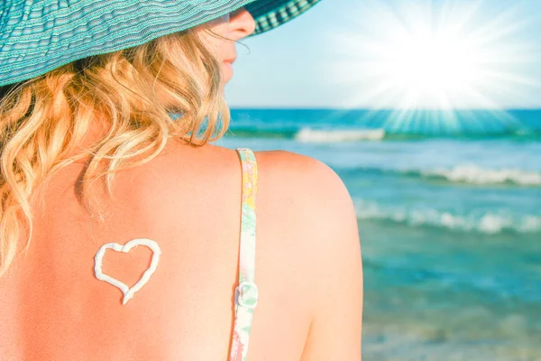 Felice ragazza con un cuore sulla schiena in riva al mare all'aperto — Foto Stock