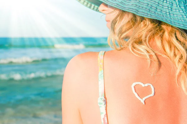 Felice ragazza con un cuore sulla schiena in riva al mare all'aperto — Foto Stock