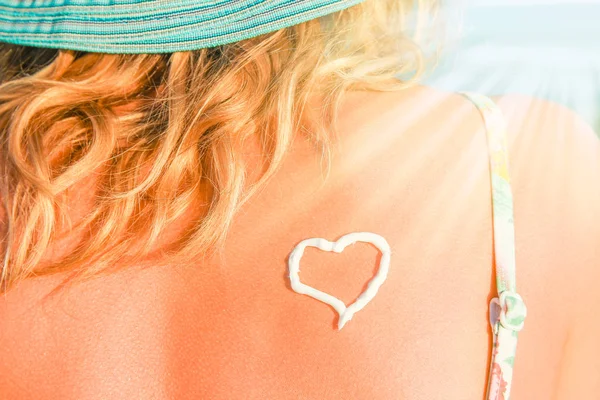 Happy girl with a heart on her back by the sea outdoors — Stock Photo, Image