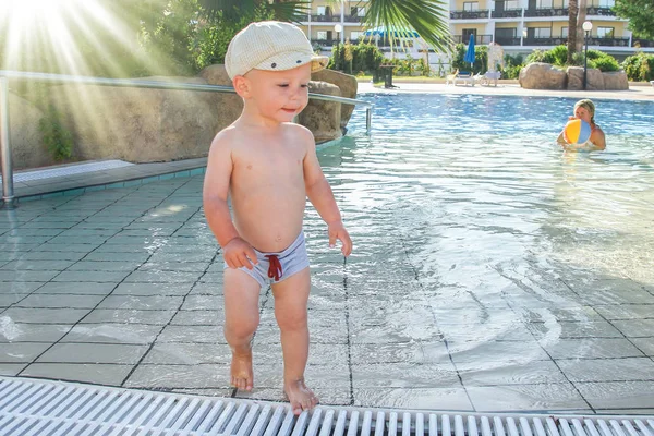 A happy child plays by the pool by the sea — Stock Photo, Image