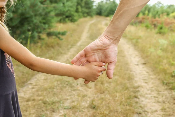 Snygga händer av en förälder och barn i naturen i en Park tillbaka — Stockfoto