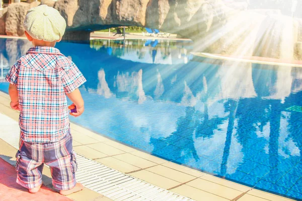 A happy child plays by the pool on the nature by the sea — Stock Photo, Image