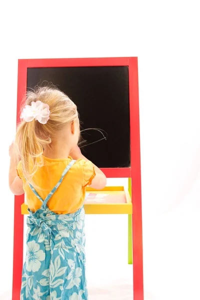 Happy baby girl beautiful painting on the easel on a white backg — Stock Photo, Image