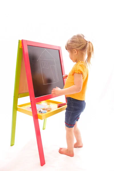 Happy baby girl beautiful painting on the easel on a white backg — Stock Photo, Image