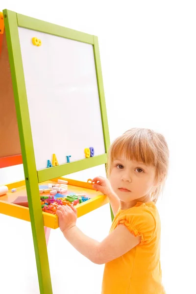 Happy baby girl beautiful painting on the easel on a white backg — Stock Photo, Image