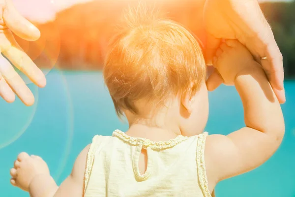 Mani di un genitore e di un bambino nella natura in un parco in riva al mare — Foto Stock