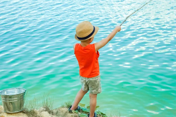 Criança feliz pesca ao largo da costa na natureza — Fotografia de Stock