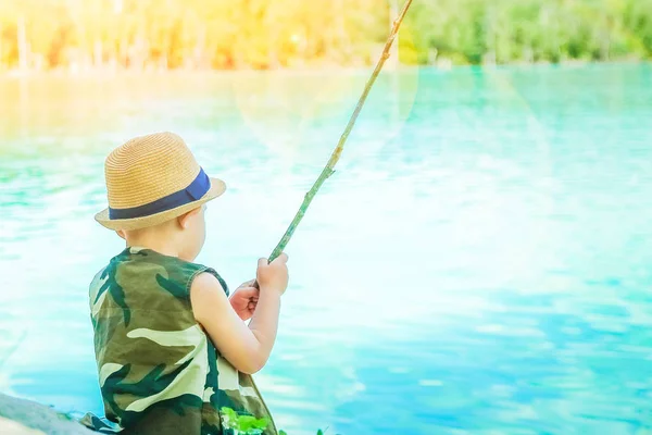 Criança feliz pesca ao largo da costa na natureza — Fotografia de Stock