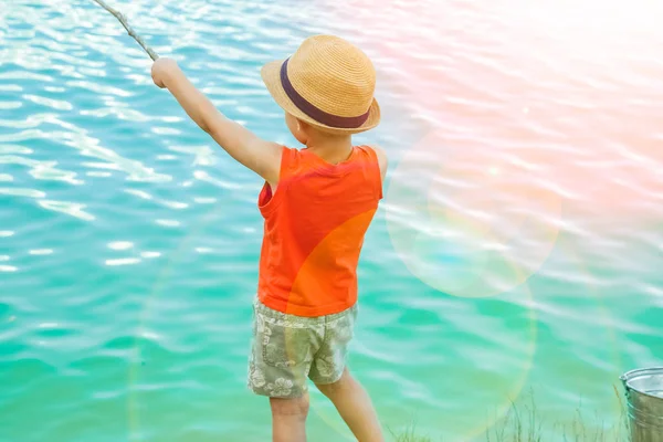 Criança feliz pesca ao largo da costa na natureza — Fotografia de Stock