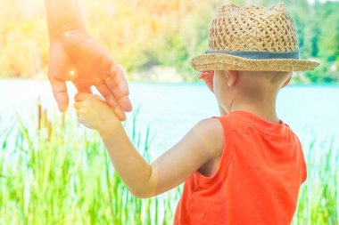 deniz tarafından bir parkta doğada bir ebeveyn ve çocuk elleri