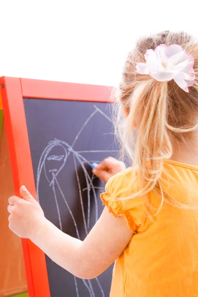 Happy baby girl beautiful painting on the easel on a white backg — Stock Photo, Image