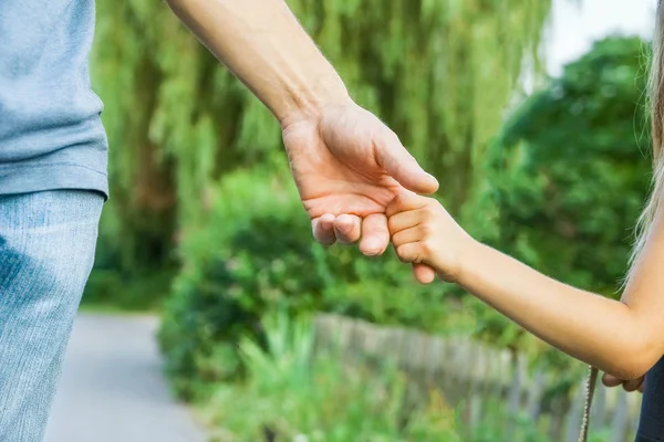 Родитель, держащий руку ребенка на счастливом фоне — стоковое фото
