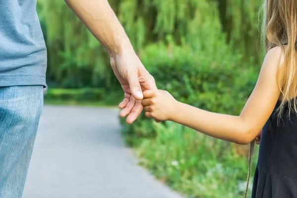 Föräldern som håller barnets hand med en lycklig bakgrund — Stockfoto