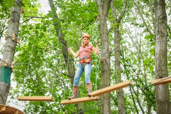 Schöne Mädchen im Park auf den Seilen erreichen Outdoor — Stockfoto