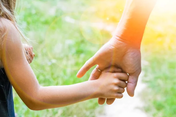 Der Elternteil hält die Hand des Kindes mit einem glücklichen Hintergrund — Stockfoto