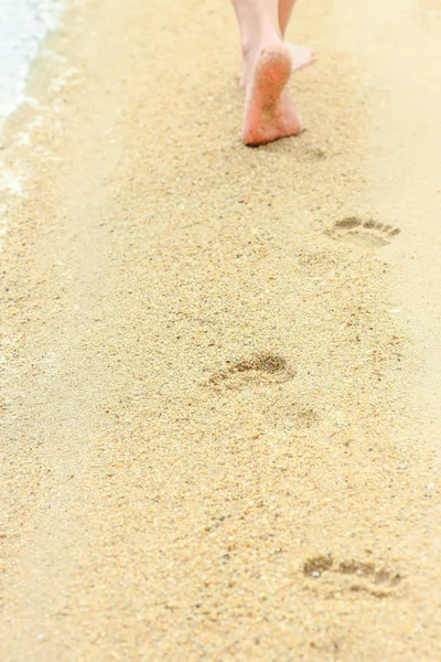 Mooie voetafdrukken in het zand door de zee achtergrond — Stockfoto
