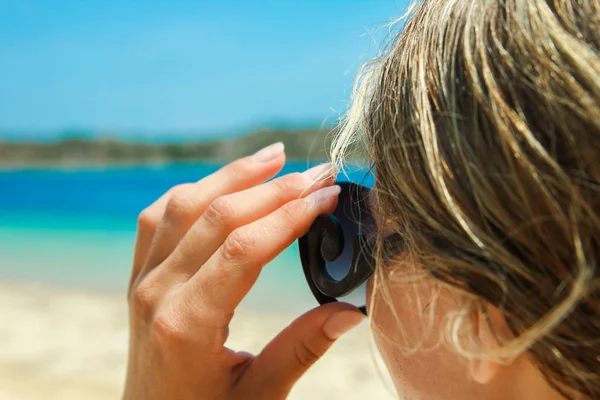 Fille heureuse avec des lunettes de soleil au bord de la mer sur fond de nature — Photo