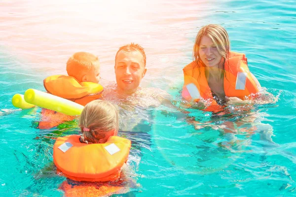 Lycklig familj leker i havet på natur bakgrund — Stockfoto