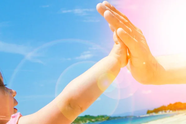 Beautiful hands of parent and child by the sea — Stock Photo, Image