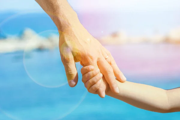 Piękne ręce rodzica i dziecka nad morzem — Zdjęcie stockowe