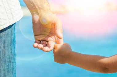 Deniz kenarındaki anne ve babanın güzel elleri.