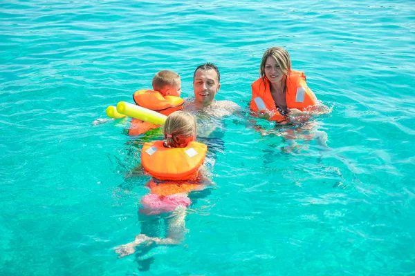 Familia feliz jugando en el mar en el fondo de la naturaleza —  Fotos de Stock
