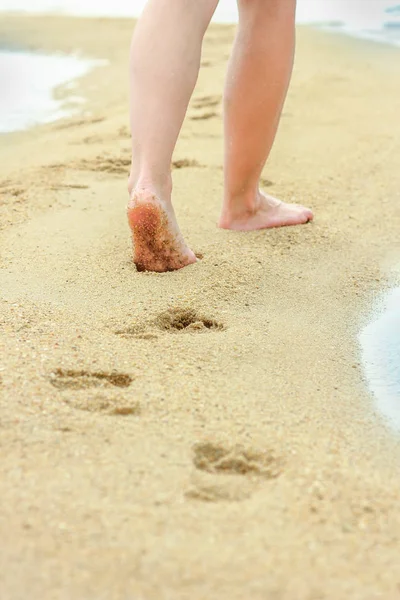 Mooie voetafdrukken in het zand door de zee achtergrond — Stockfoto