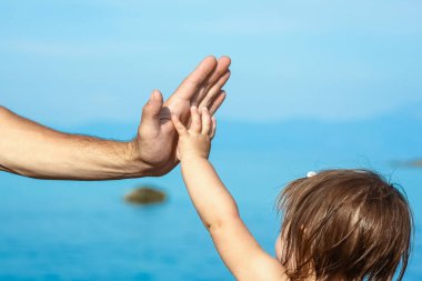 Deniz kenarındaki anne ve babanın güzel elleri.