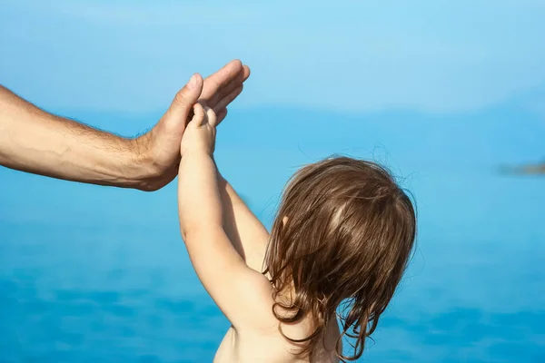 Belles mains de parent et enfant au bord de la mer — Photo