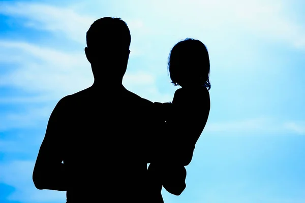 Felice genitore con bambino in natura dalla silhouette del mare — Foto Stock