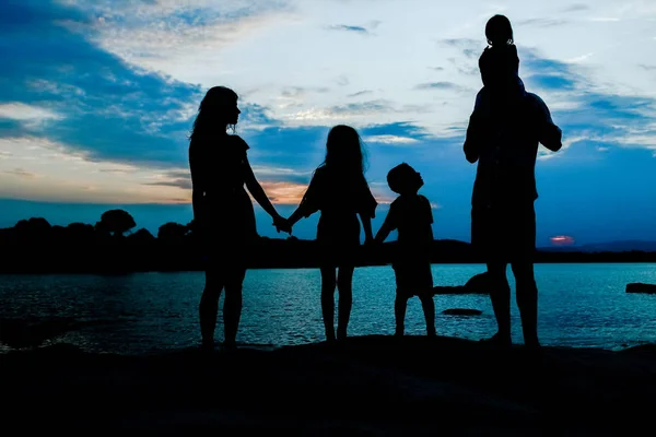 Família feliz pelo mar na natureza silhueta fundo — Fotografia de Stock